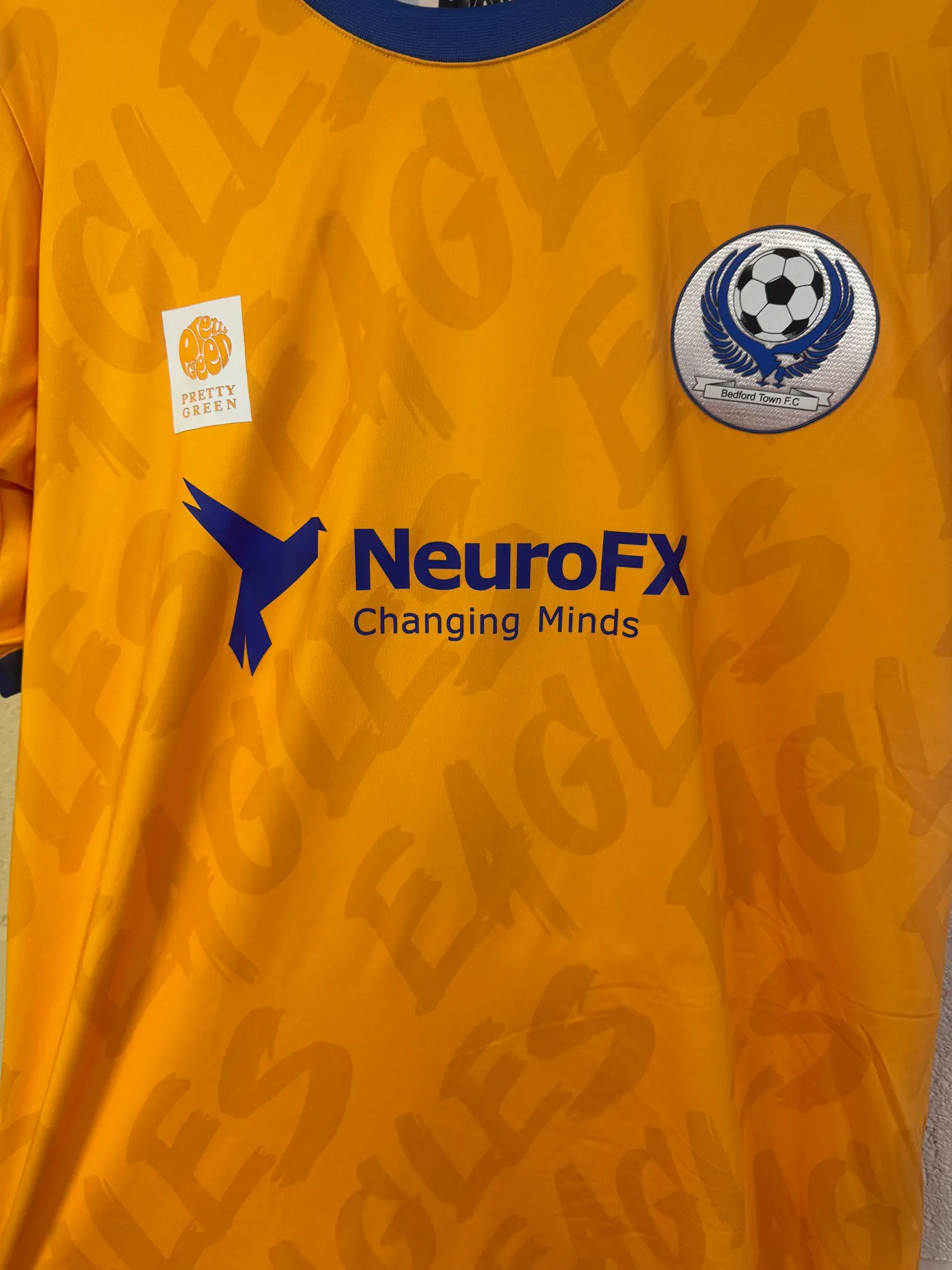Close-up of the Bedford Town FC Academy shirt showing the club crest and the NeuroFX Changing Minds logo across the chest