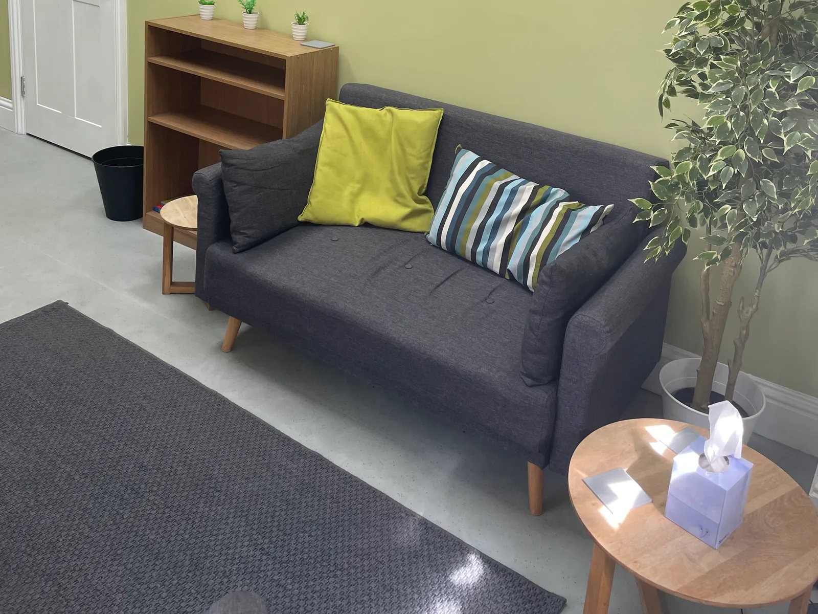 The consulting room at the NeuroFX Bedford clinic, with a sofa, cushions and soft natural light