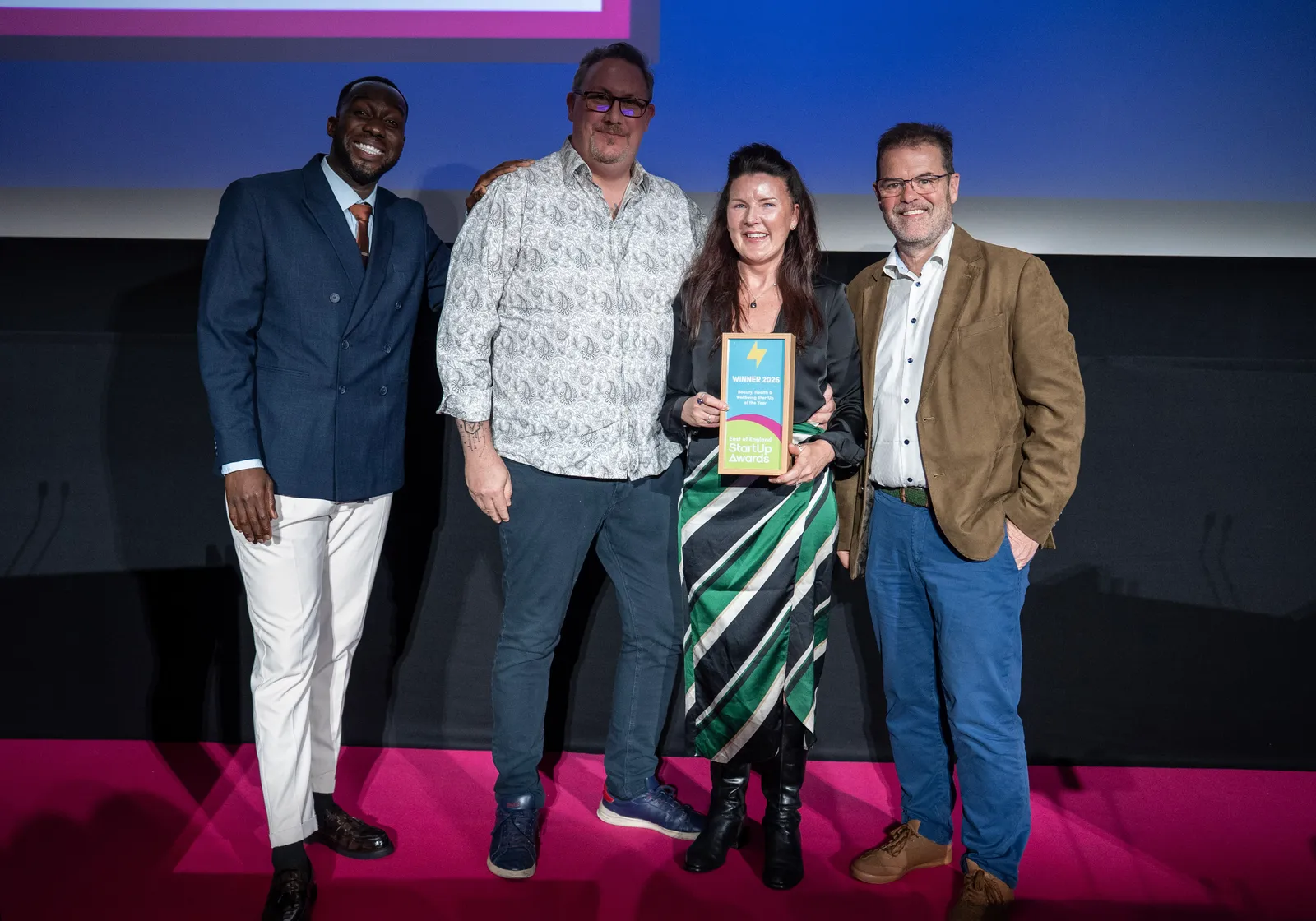 Paul and Tina Fox collecting the Beauty, Health and Wellbeing StartUp of the Year award on stage at the East of England StartUp Awards 2026