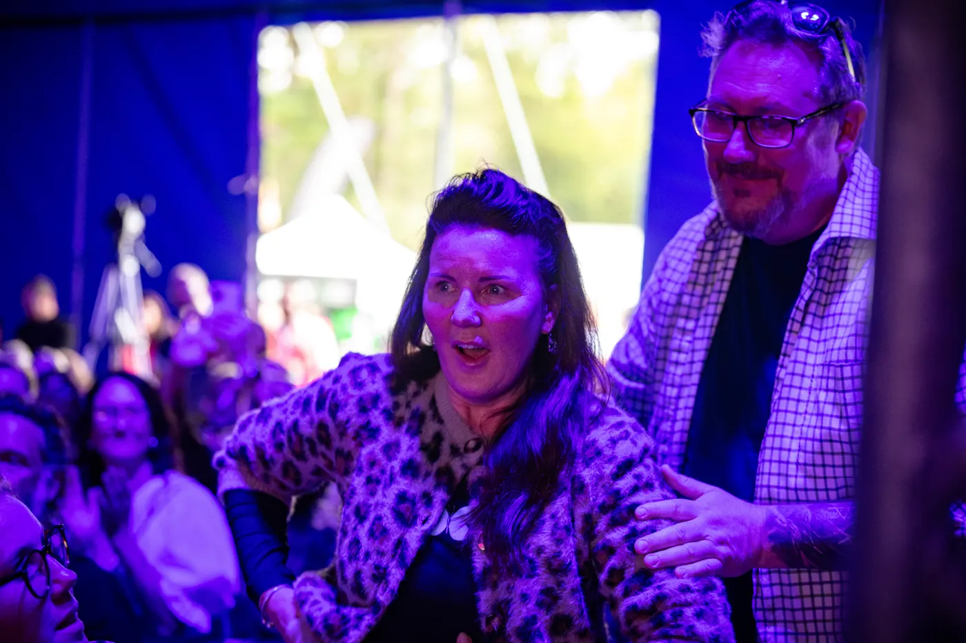 Tina Fox's face at the moment NeuroFX is announced as national winner, Paul behind her with a hand on her shoulder, in the crowd at the national final