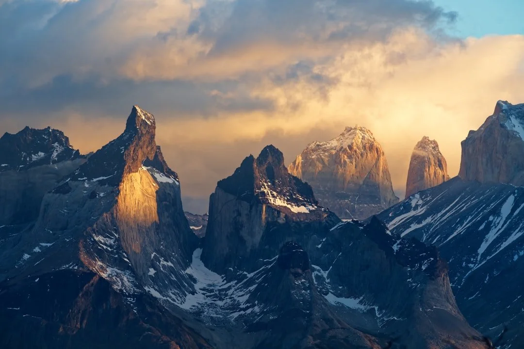 Dramatic mountain peaks catching the last light beneath heavy cloud